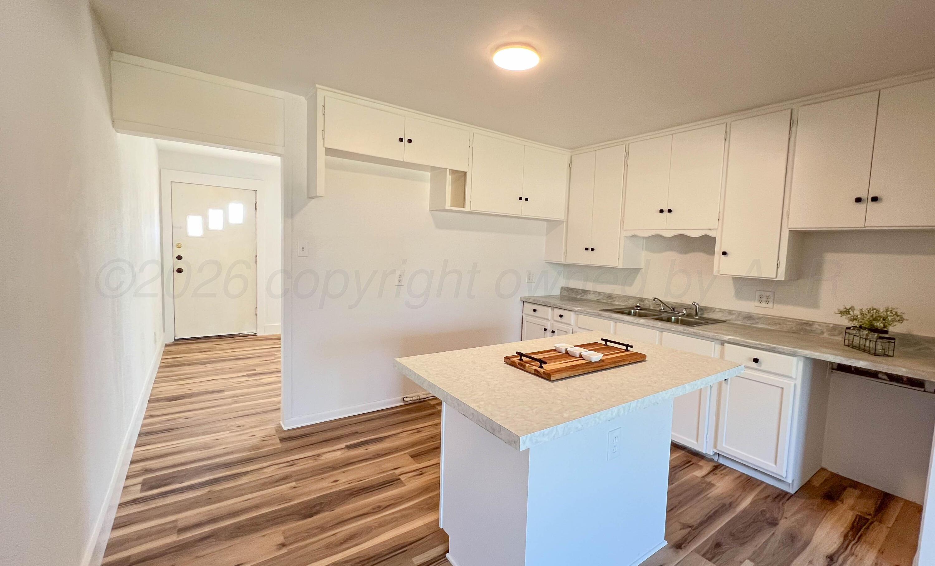 4410 South Ong Street Amarillo, TX 79110 - Photo 6 of 22 a white kitchen with sink and cabinets