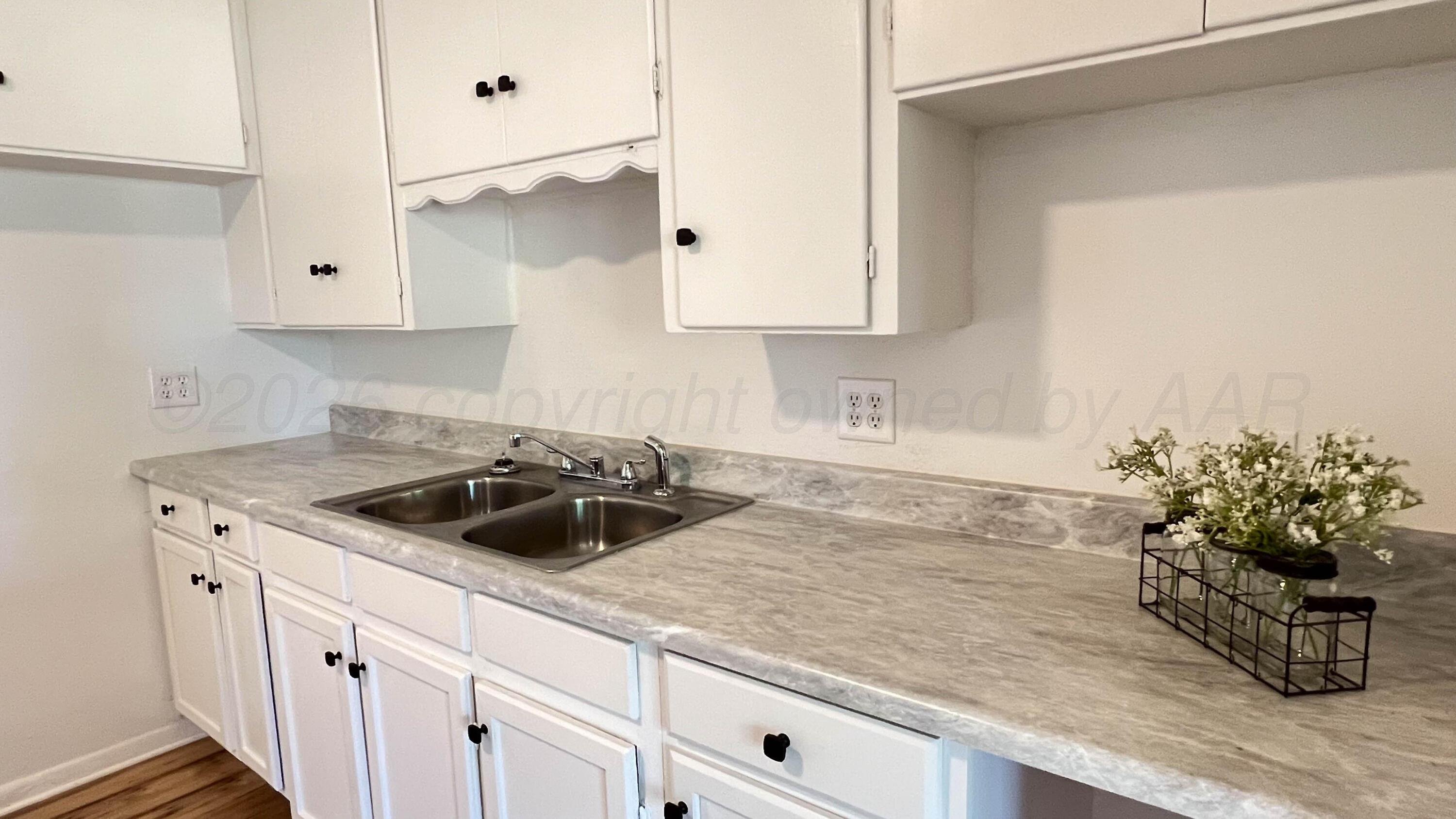 4410 South Ong Street Amarillo, TX 79110 - Photo 7 of 22 a kitchen with granite countertop a sink a stove and cabinets