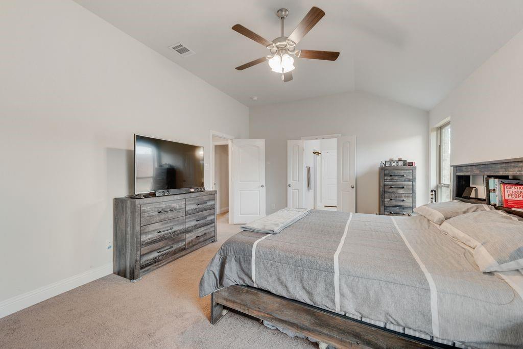 1202 Holly Street Cleburne, TX 76033 - Photo 20 of 36 a bedroom with a large bed and a flat screen tv