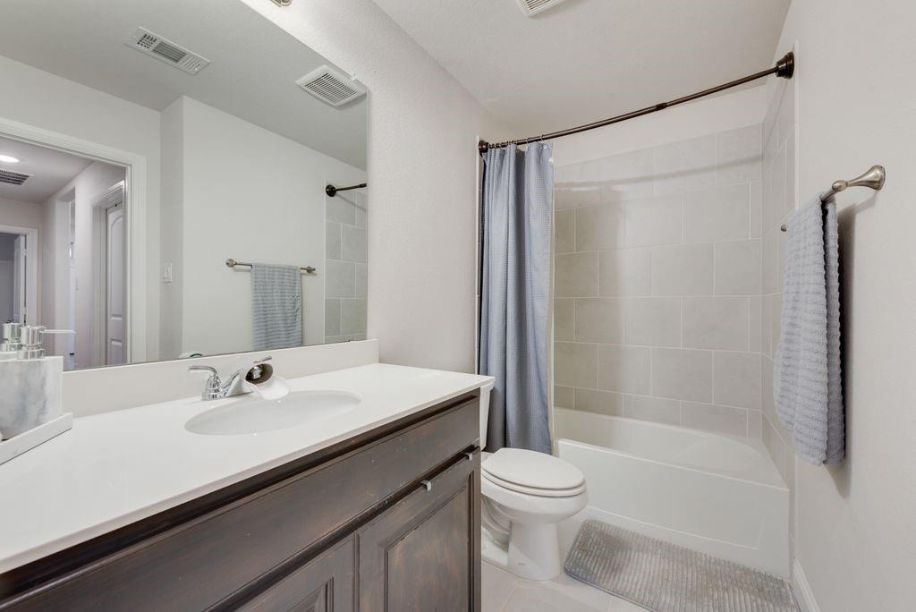 1202 Holly Street Cleburne, TX 76033 - Photo 27 of 36 a bathroom with a sink a toilet and shower