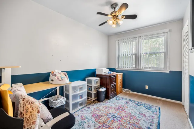a spacious bedroom with a bed and a chandelier