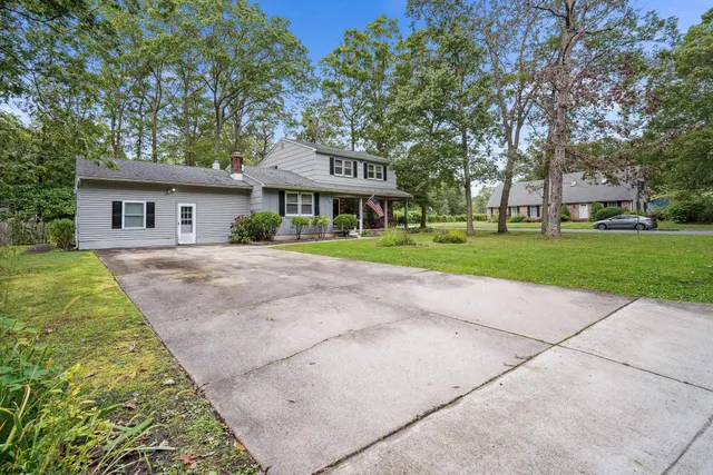 a view of a house with a backyard and a large tree