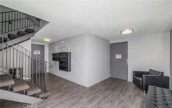 a view of a livingroom with wooden floor and staircase