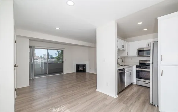 a view of a kitchen with wooden floor and electronic appliances