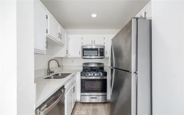 a kitchen with stainless steel appliances a refrigerator and a stove top oven