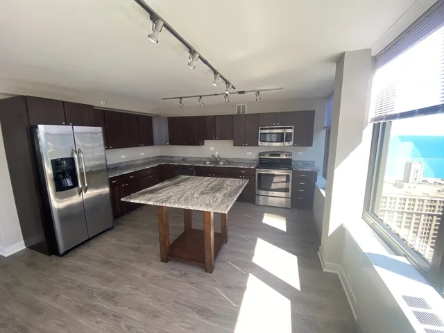 a kitchen with stainless steel appliances granite countertop a stove and a refrigerator