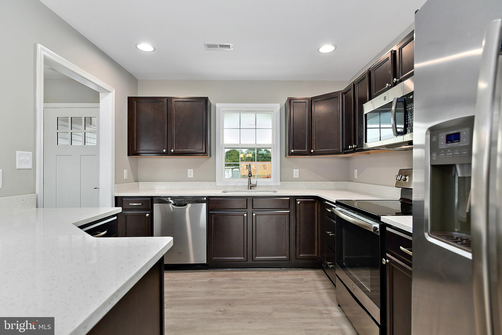 153 Fooks Road Bishopville, MD 21813 - Photo 9 of 30 a kitchen with stainless steel appliances granite countertop a sink stove and refrigerator