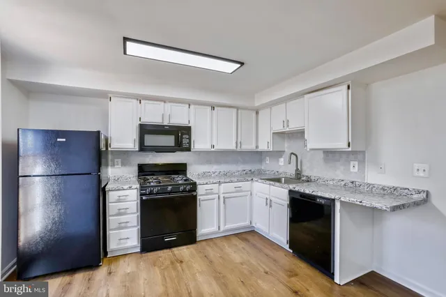 a kitchen with a refrigerator sink and stove top oven