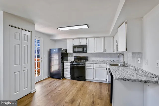 a kitchen with granite countertop stainless steel appliances and wooden cabinets