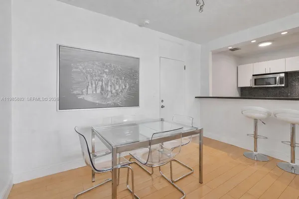 a kitchen with stainless steel appliances kitchen island a table and chair