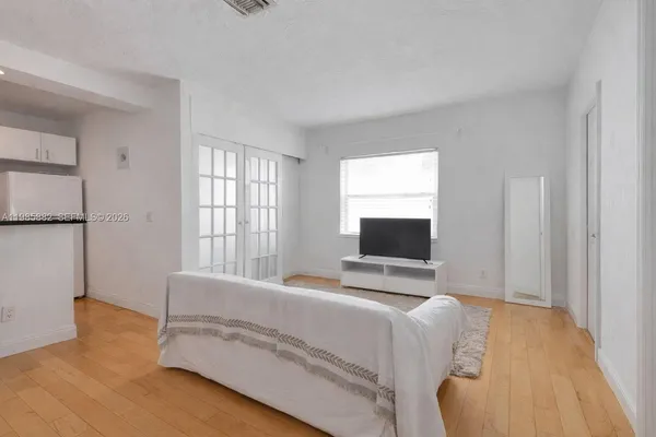 a bedroom with a bed and a flat tv screen on the dresser