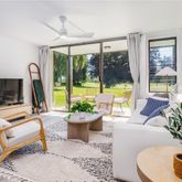a living room with furniture a flat screen tv and a large window