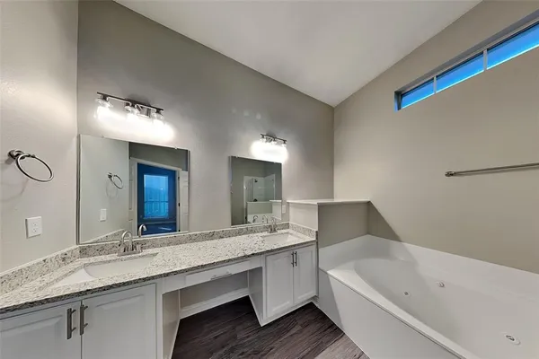 a bathroom with a granite countertop sink mirror and bathtub