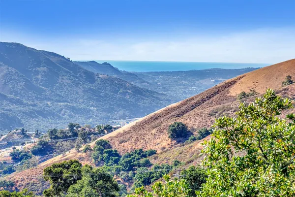 a view of a dry yard with mountains in the background