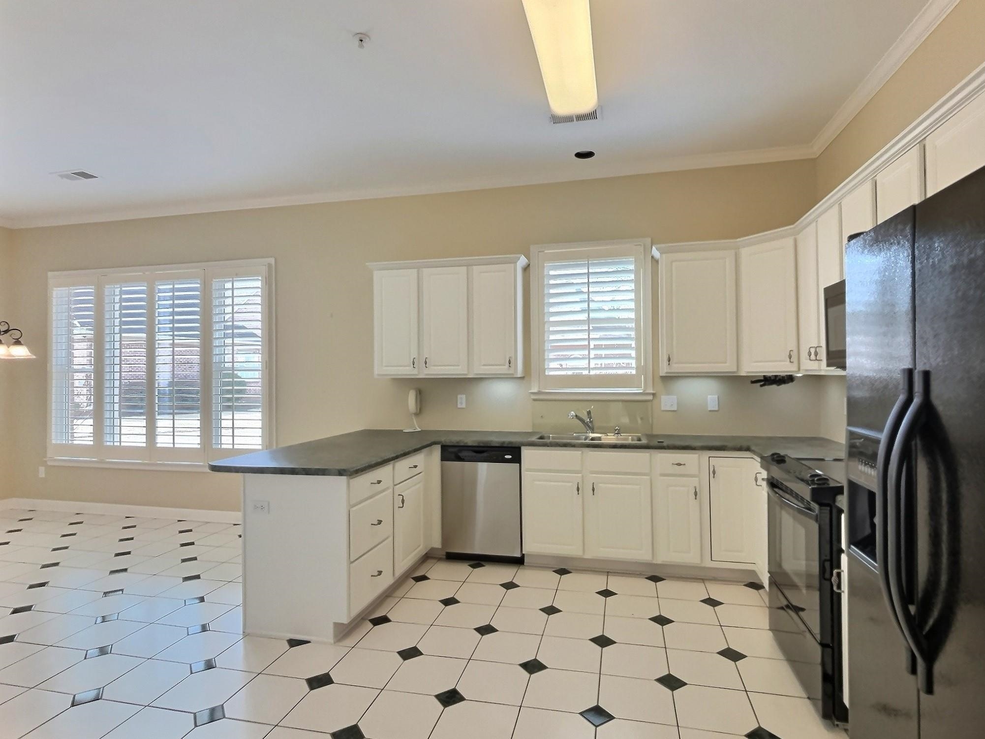 1748 Higginson Square Collierville, TN 38017 - Photo 7 of 23 a kitchen with granite countertop a sink a stove a refrigerator and white cabinets