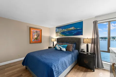 a bedroom with a bed and a painting on the wall