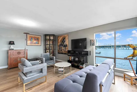 a living room with furniture a flat screen tv and a large window