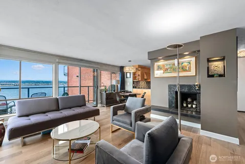 a living room with fireplace furniture and a large window