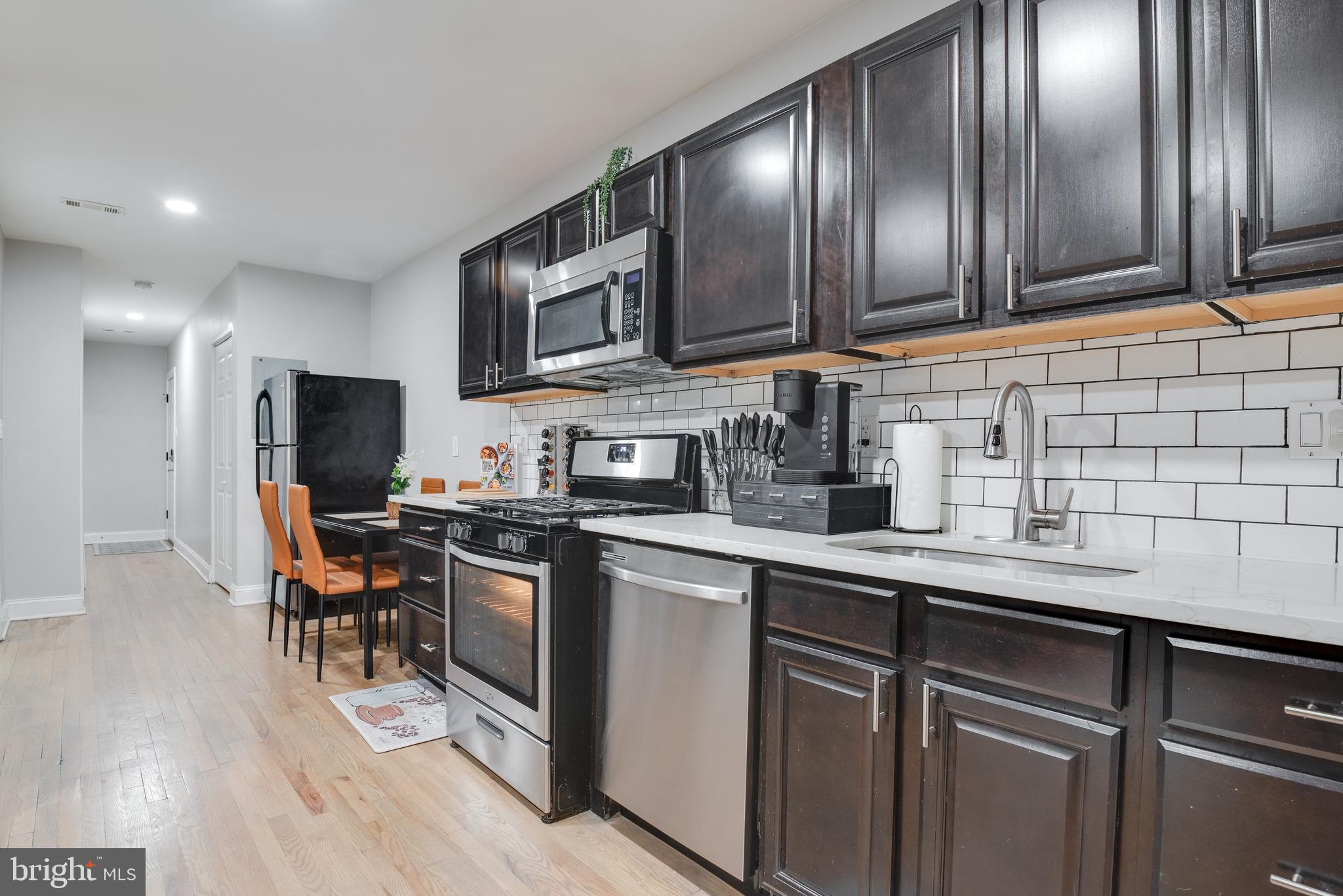 1255 Raum Street Northeast, Unit 1 Washington, DC 20002 - Photo 11 of 31 a kitchen with stainless steel appliances granite countertop a sink stove and microwave