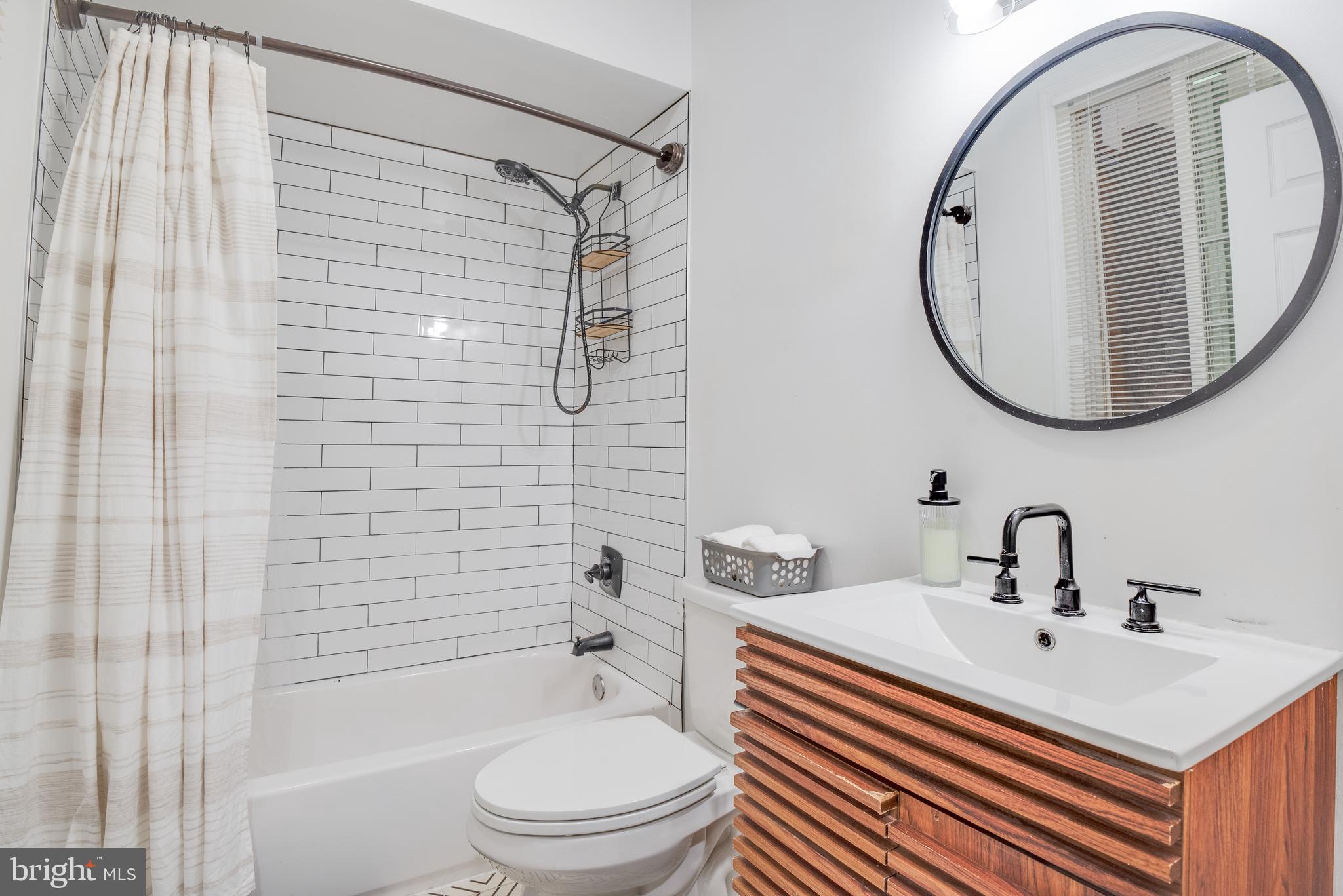 1255 Raum Street Northeast, Unit 1 Washington, DC 20002 - Photo 14 of 31 a bathroom with a sink toilet and shower
