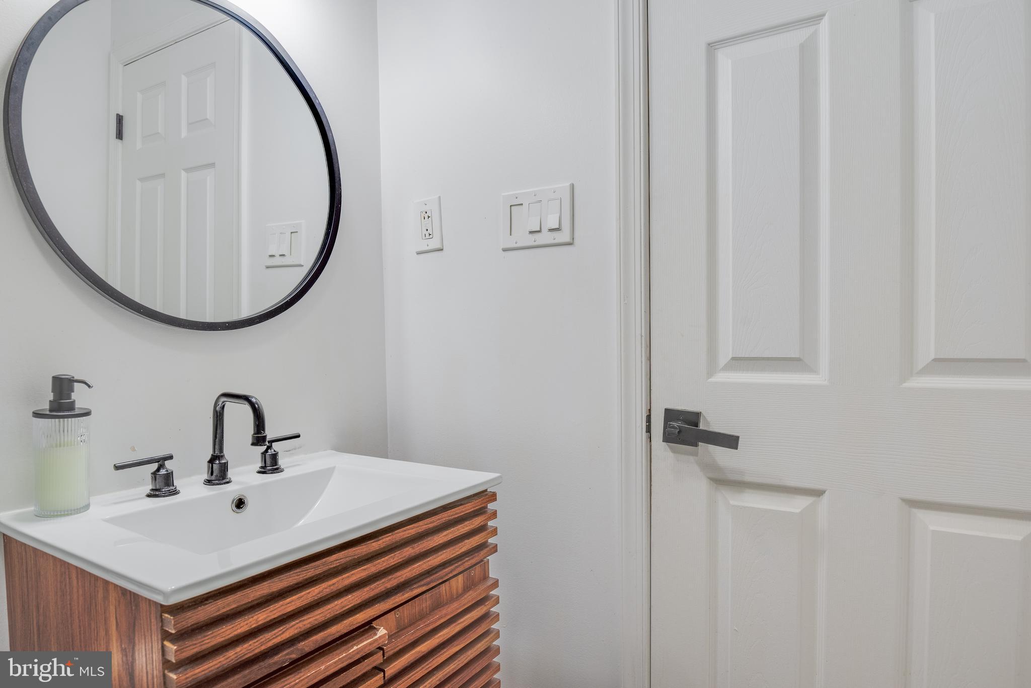 1255 Raum Street Northeast, Unit 1 Washington, DC 20002 - Photo 17 of 31 a bathroom with a sink and a mirror