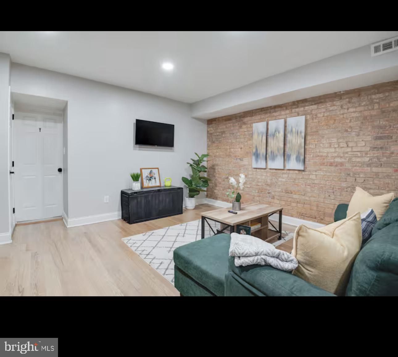 1255 Raum Street Northeast, Unit 1 Washington, DC 20002 - Photo 2 of 16 a living room with furniture and a flat screen tv