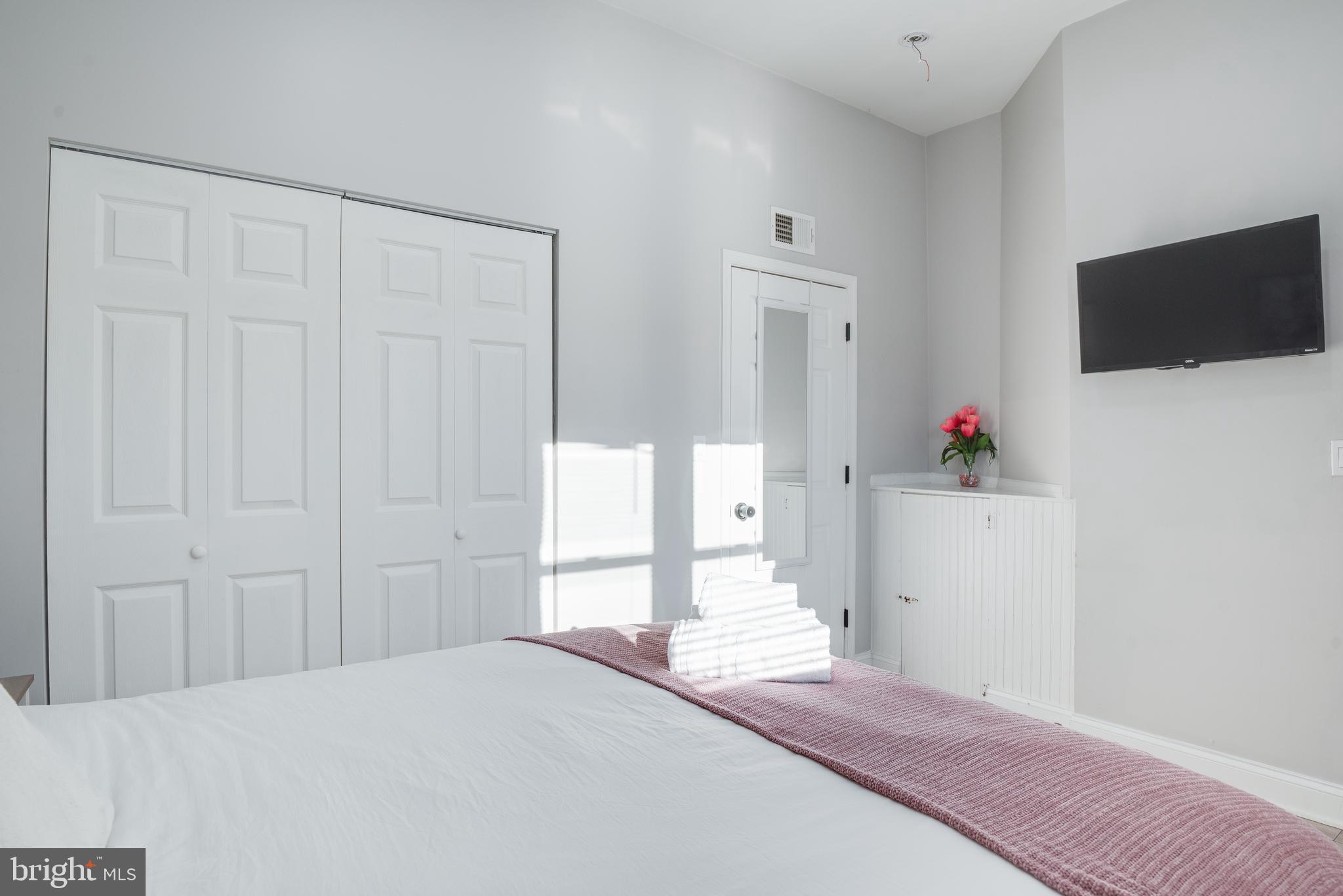 1255 Raum Street Northeast, Unit 1 Washington, DC 20002 - Photo 23 of 31 a bedroom with a bed and a flat screen tv