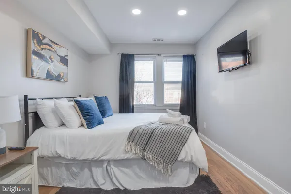 a bedroom with a bed and painting on the wall