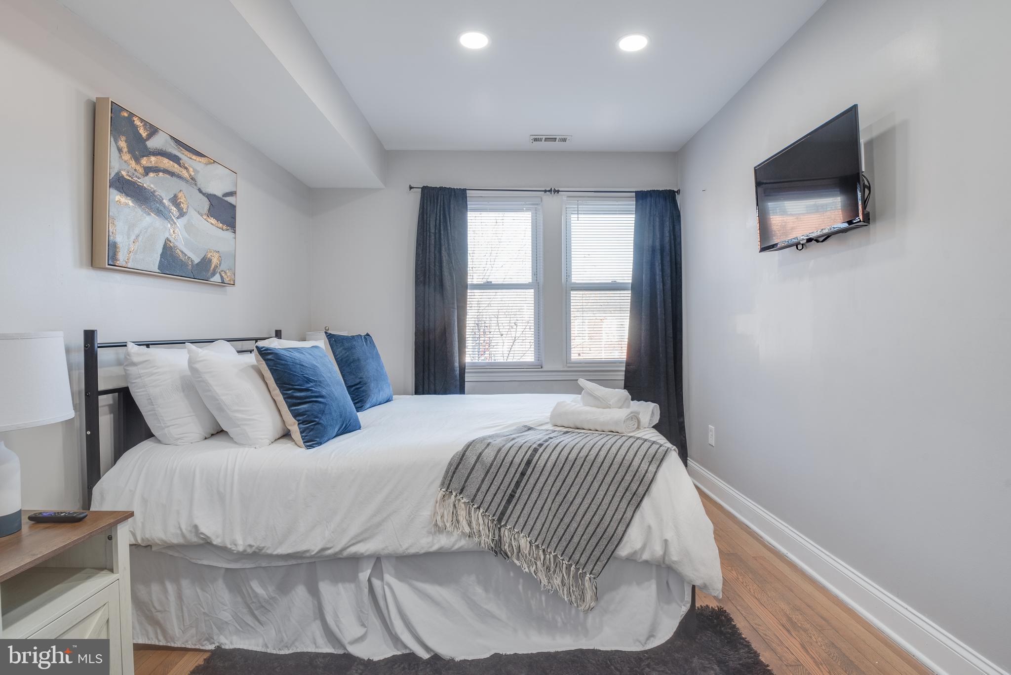 1255 Raum Street Northeast, Unit 1 Washington, DC 20002 - Photo 26 of 31 a bedroom with a bed and a flat screen tv