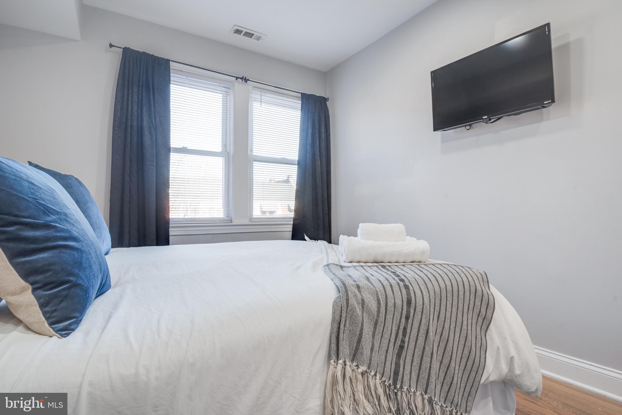 1255 Raum Street Northeast, Unit 1 Washington, DC 20002 - Photo 27 of 31 a bedroom with a bed and a flat screen tv