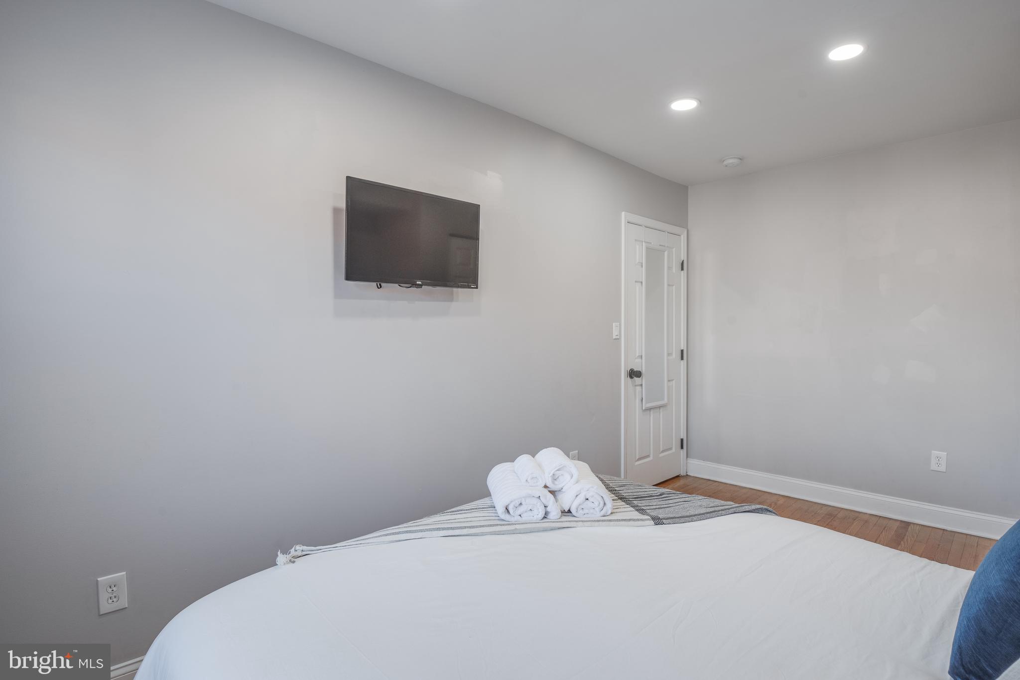 1255 Raum Street Northeast, Unit 1 Washington, DC 20002 - Photo 29 of 31 a white bed sitting in a bedroom next to a small bathroom