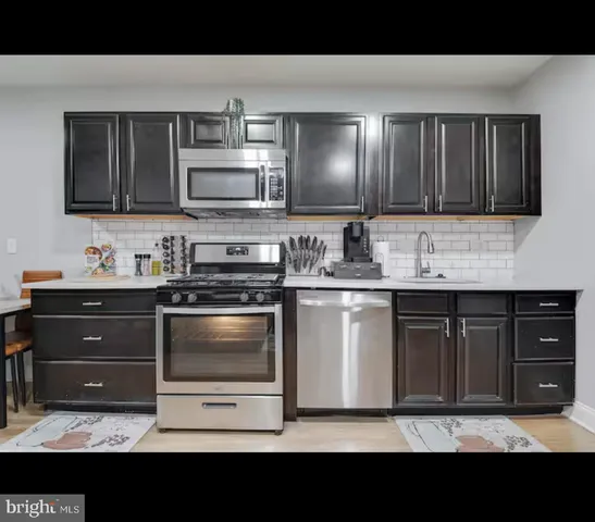 a kitchen with a sink and stainless steel appliances