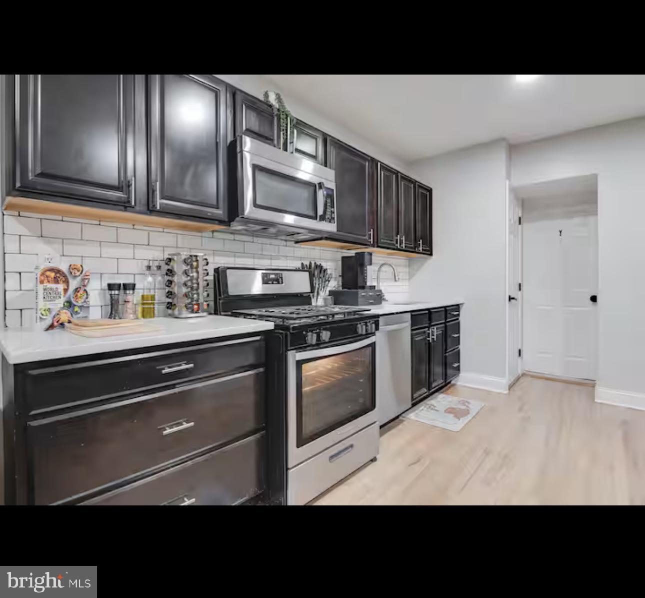 1255 Raum Street Northeast, Unit 1 Washington, DC 20002 - Photo 6 of 16 a kitchen with stainless steel appliances kitchen island granite countertop a stove top oven