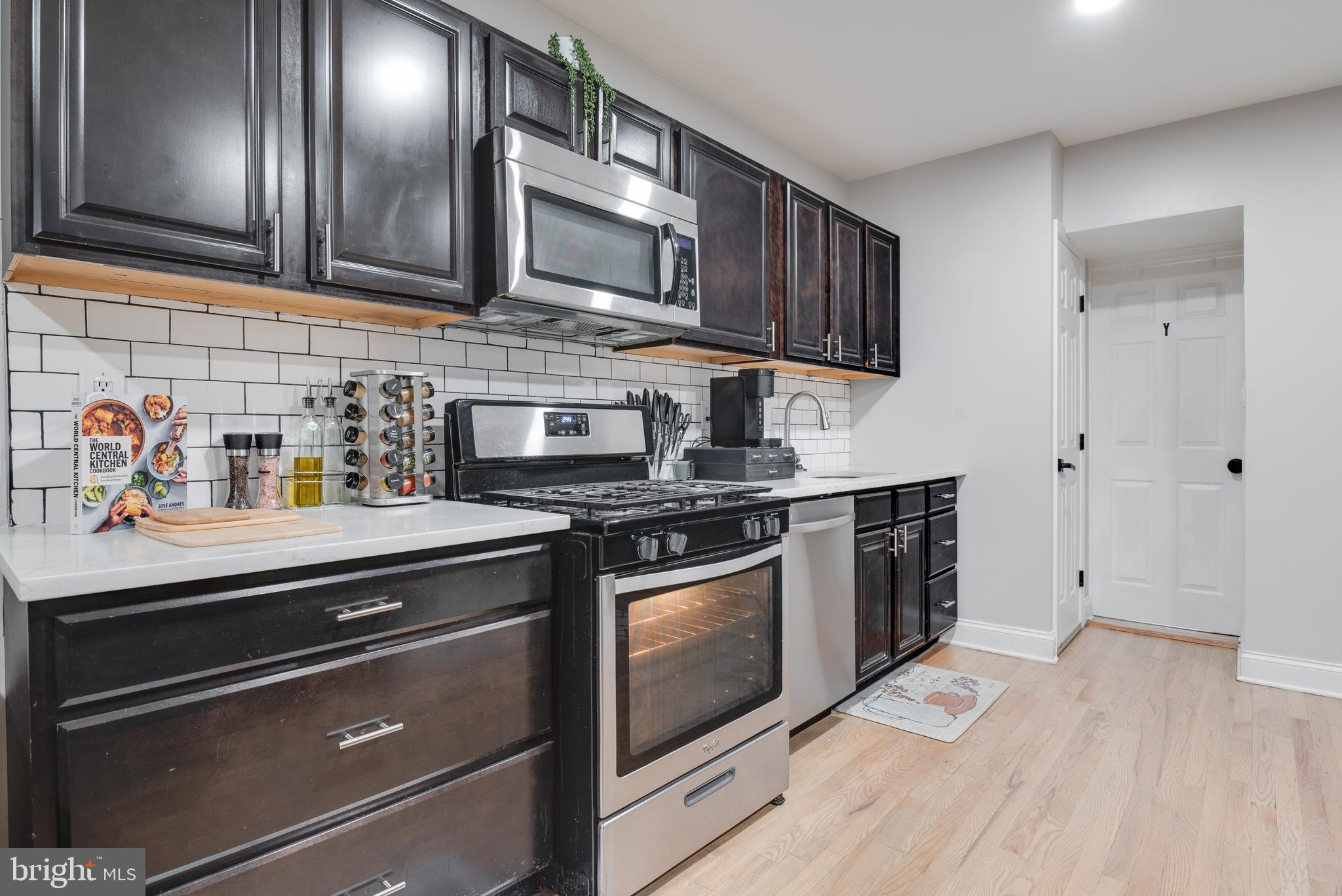 1255 Raum Street Northeast, Unit 1 Washington, DC 20002 - Photo 7 of 31 a kitchen with stainless steel appliances granite countertop a stove microwave and sink