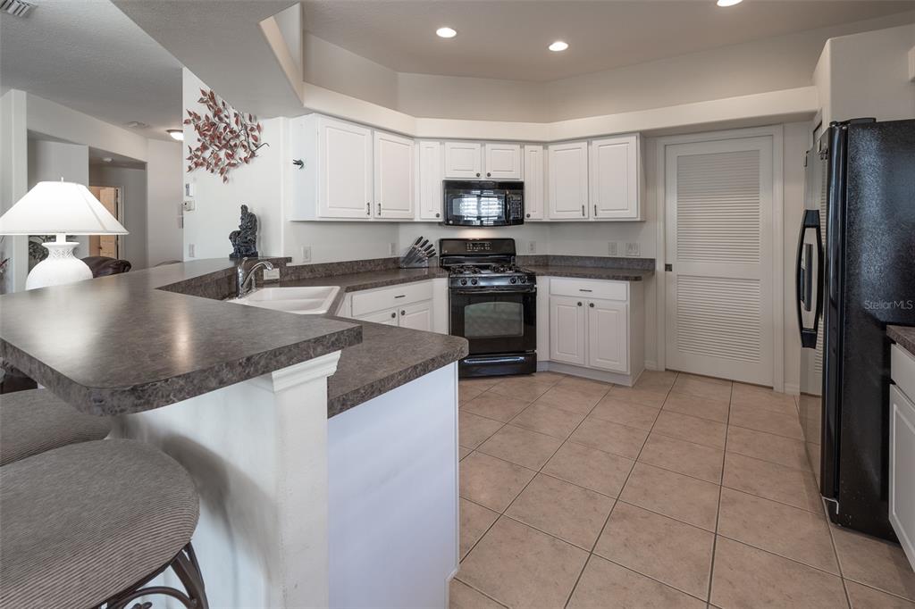 15803 Southwest 11th Court Road Ocala, FL 34473 - Photo 14 of 59 a kitchen with kitchen island granite countertop a sink a counter top space appliances and cabinets
