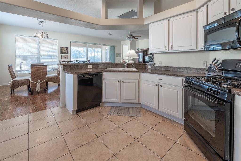 15803 Southwest 11th Court Road Ocala, FL 34473 - Photo 17 of 59 a kitchen with stainless steel appliances granite countertop a stove a sink and a microwave