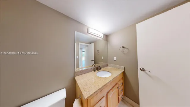 a bathroom with a granite countertop double vanity sink a mirror and a shower