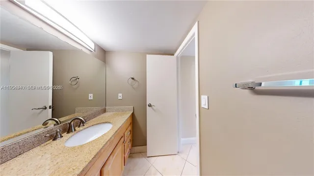 a bathroom with a granite countertop sink and a mirror