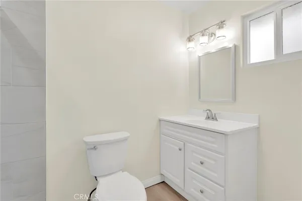 an empty room with wooden floor ceiling fan and windows