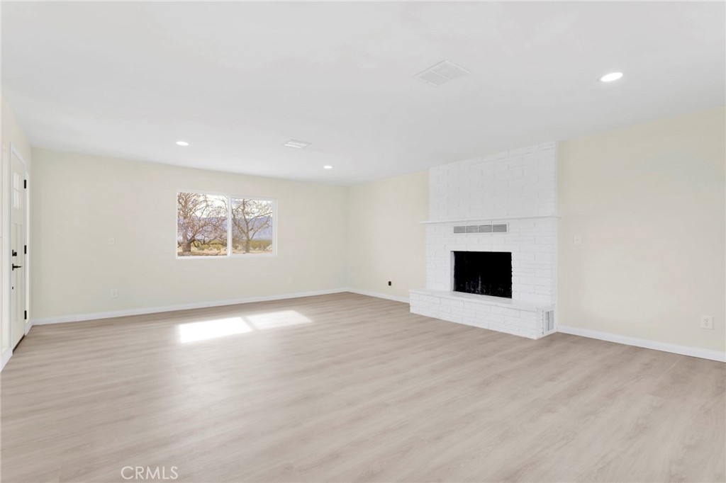 47424 Paddington Landers, CA 92285 - Photo 54 of 67 an empty room with wooden floor and fireplace