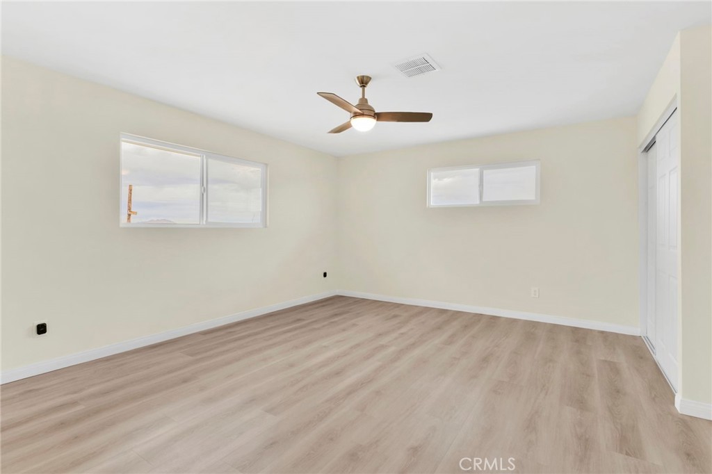 47424 Paddington Landers, CA 92285 - Photo 64 of 67 an empty room with wooden floor ceiling fan and windows
