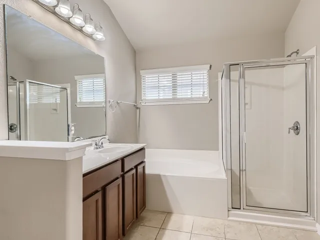 a bathroom with a tub sink and mirror