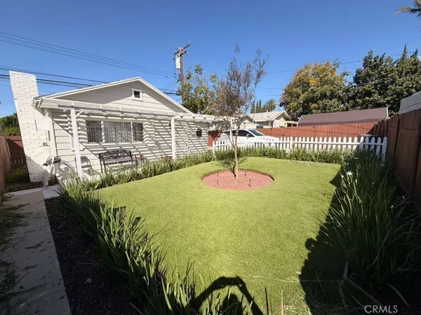 a view of a house with backyard and sitting area