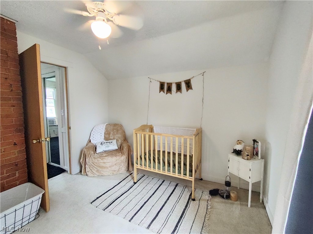 617 Mill Road Ravenna, OH 44266 - Photo 22 of 25 Bedroom with a textured ceiling, vaulted ceiling, brick wall, light carpet, and ceiling fan