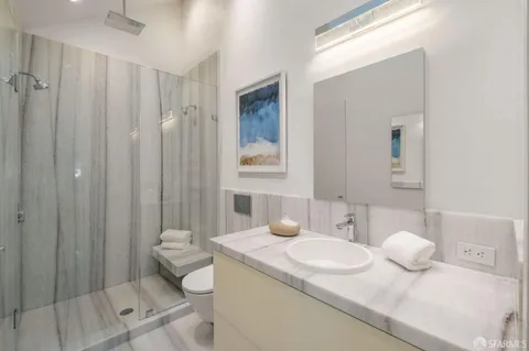 a bathroom with a granite countertop sink a toilet and a mirror