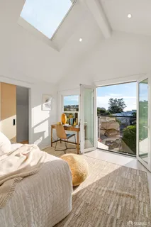 a bedroom with a bed and large windows