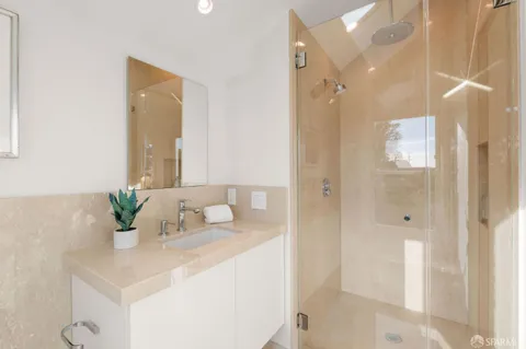 a bathroom with a granite countertop sink mirror and shower