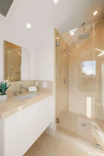 a bathroom with a granite countertop sink mirror and shower