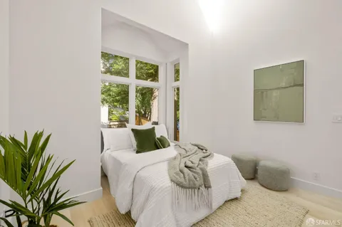 a bedroom with a bed and a potted plant