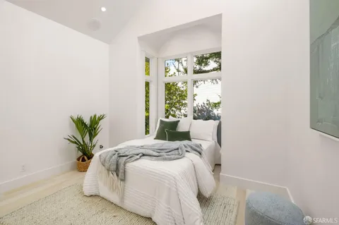 a bedroom with a bed and a potted plant